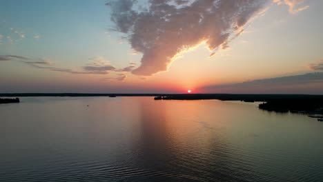 Aerial-view-of-sunset-over-calm-lake-with-reflection,-Michigan