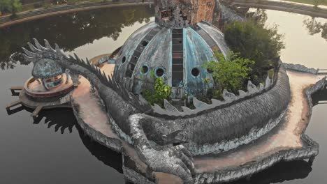 Big-dragon-at-Thuy-Tien-lake-Abandoned-Water-Park-Vietnam,-aerial