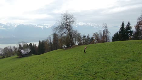 Cinematic-aerial-drone-Swiss-Alps-countryside-beautiful-woman-dancing-in-the-fog-hillside-sounds-of-music-scene-Thun-Bern-Interlocken-Switzerland-mountainside-circling-slowly-right-movement