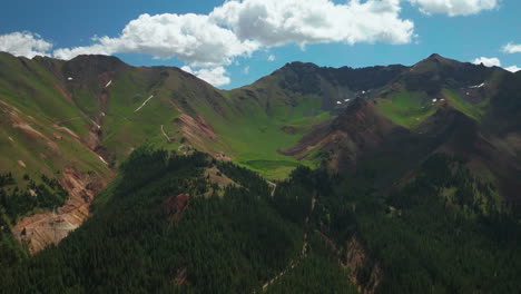 Aerial-cinematic-drone-summer-high-altitude-Silverton-Mountain-Ski-Resort-southern-Colorado-blue-sky-late-morning-stunning-lush-green-blue-sky-partly-cloudy-Rocky-Mountains-forward-reveal-motion