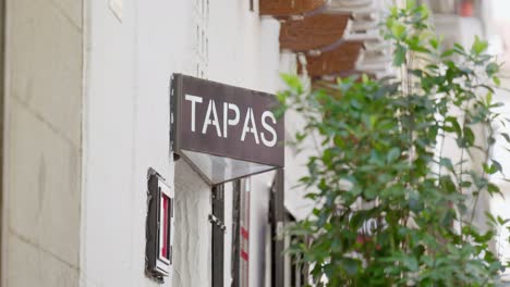 Static-video-of-sign-with-TAPAS,-tree-in-the-foreground