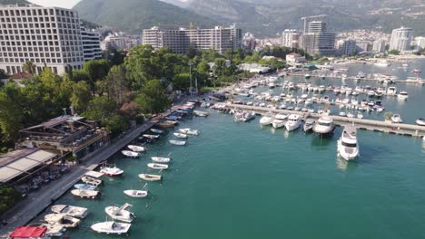 Aerial-view-of-Budva-marina,-Montenegro-with-boats-and-city-backdrop