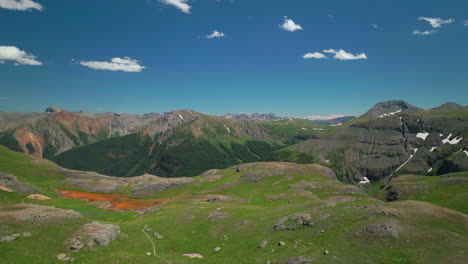 Aerial-drone-cinematic-high-altitude-Ice-Lake-Basin-Island-Lake-trail-lush-green-hike-Silverton-Ouray-Red-Mountain-Pass-Colorado-dreamy-heavenly-Rockies-scene-summer-peaks-down-forward-motion