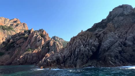 Breathtaking-volcanic-rock-formations-of-Calanques-de-Piana-in-Corsica-island-as-seen-from-moving-boat-in-summer-season,-France