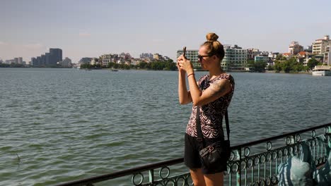 Young-woman-at-Tay-Ho-Lake-capturing-images-of-the-scenery-around-her