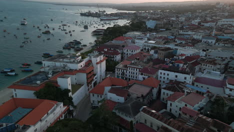 Aerial-view-of-water-front-Stone-Town,-old-part-of-Zanzibar-City-in-the-morning,-4K-Drone