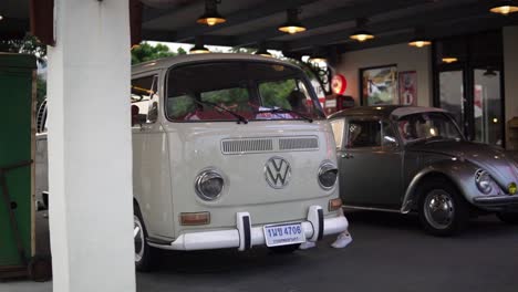 Modelo-Femenino-Revisando-Autos-Antiguos-Volkswagen-Clásicos-En-Exhibición-Pública-En-El-Mercado-Nocturno-Rot-Fai-En-Bangkok,-Tailandia