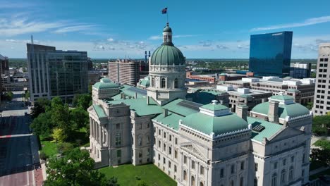Indiana-State-Capitol-building-with-its-iconic-green-dome,-surrounded-by-modern-structures-under-a-clear-blue-sky