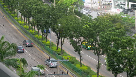 Vista-Desde-Lo-Alto-De-Una-Calle-De-La-Ciudad,-Con-Coches-Y-Transporte-Público-Pasando-Por-Bangkok,-Tailandia