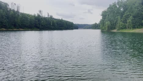 Kleiner-See-Mit-Bewaldeten-Rändern-In-Deutschland-Mit-Starkem-Wind-Auf-Der-Wasseroberfläche