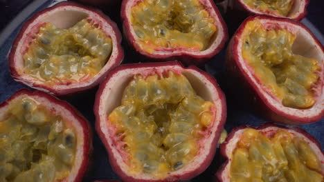Close-up-rotating-passion-fruits,-juicy-tropical-maracuya,-exotic-fruits,-4K-macro-shot