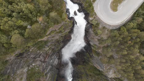 Aerial-descending-down-Wasserfälle-waterfall-and-serpentine-road-at-Åmotan-gorge,-Norway