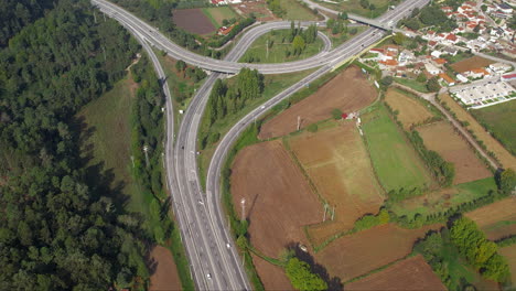 Aerial-shot-of-Portugal's-highway-amidst-farmland-and-forested-areas