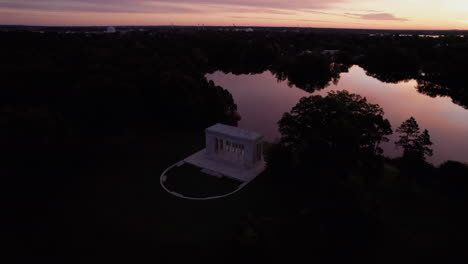 Circular-drone-footage-during-an-orange-sunset-shows-the-Roger-Williams-Park-Temple-to-Music