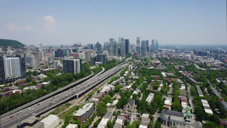 Aerial-tracking-shot-of-the-Boulevard-Ville-Marie-and-Petite-Bourgogne,-in-sunny-Montreal,-Canada