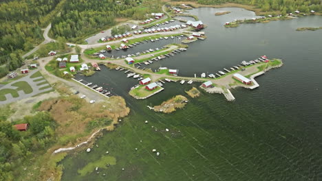 Panoramic-Aerial-View-Of-Mooring-Boats-At-The-Marina-Bay-With-Red-Houses-During-Autumn-In-Finland