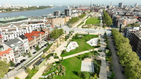 Aerial-view-showing-idyllic-park-area-in-city-of-Antwerp-during-sunny-day-with-schelde-river-in-Background