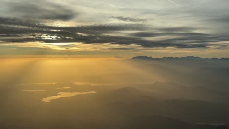 A-pilot’s-perspective-of-the-italian-Alps-mountains-while-flying-northbound-at-9000m-high-near-the-Lago-Maggiore-juste-before-sunset,-at-the-golden-minute