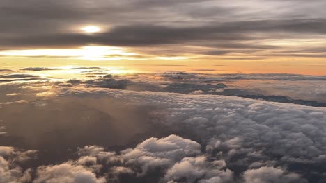 Stunning-aerial-side-view-of-a-sunset-shot-from-a-jet-cockpit-while-fying-over-the-Italian-Alps-and-a-layer-of-clouds-in-a-real-flight-at-9000m-high