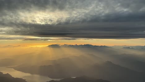 An-unique-pilot’s-point-of-view-while-flying-over-the-italian-Alps-mountains-near-Lago-Maggiore-at-sunset-with-a-cloudy-sky