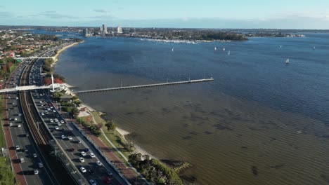Aerial-view-of-traffic-on-highway-with-swan-river-during-sunset-time-in-Perth-City