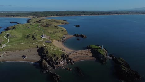 Aerial-view-looking-down-Ynys-Llanddwyn-island-at-sunrise-with-coastal-lighthouse
