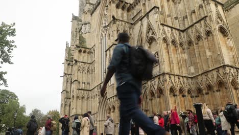 Low-angle-shot-of-tourists-queueing-up-waiting-to-get-inside-York-Minster