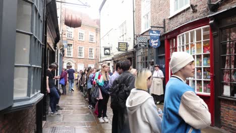 Hand-held-panning-shot-showing-the-queue-outside-the-Ghost-Merchants-in-the-Shambles,-York