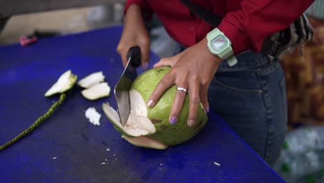Thai-Street-Food-Vendor-Cutting-Open-Green-Coconut-Using-Knife-Cutting-Technique-And-Skill