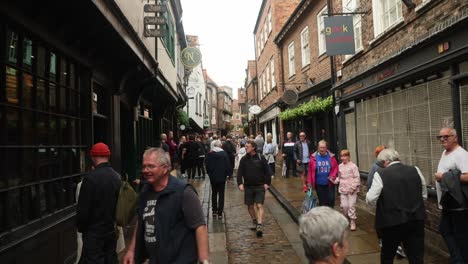 Hand-held-shot-of-tourists-walking-through-the-busy-historic-Shambles-in-York