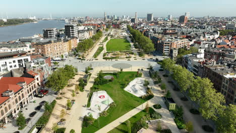Drone-flyover-park-in-zuid-District-of-Antwerp-with-schelde-river-during-sunny-day