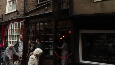 Hand-held-shot-of-tourists-waiting-outside-the-ghost-merchants-in-the-Shambles,-York
