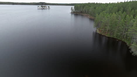 Dark-Watered-Forest-Lake-Surrounded-By-Conifer-Trees-During-Autumn-In-Sweden