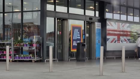 Shoppers-entering-and-leaving-ALDI-supermarket-during-British-cost-of-living-and-high-inflation-crisis