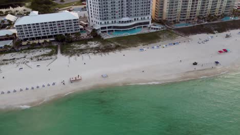 Aerial-view-drone-camera-video-Panama-city-beach-Florida-Luxurious-tropical-beach-resort-or-hotel-with-beach-service-colorful-umbrellas-on-the-beachfront,-Beach-Aerial