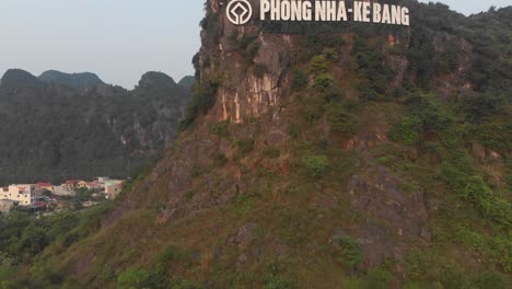 Rising-up-above-big-Phong-nha-ke-bang-sign-at-mountain-Vietnam,-aerial