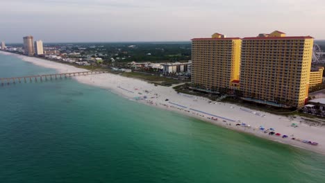 Panoramic-Aerial-view-Panama-city-beach-Gulf-of-Mexico-Aerial-view-during-morning-dawn-with-fishing-pier-and-hotel-resort-building-in-the-background