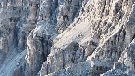 Close-up-view-of-the-Dolomites'-majestic-rock-formations-captured-in-a-tele-scene,-showcasing-the-intricate-details-of-the-stratified-cliffs-amidst-a-hazy-backdrop