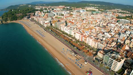 Aerial-view,-circular-flight-control-of-Lloret-De-Mar-beach-on-the-Costa-Brava-of-Gerona,-few-people-on-the-beach