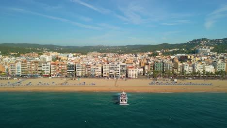 passenger-boat,-leaving-from-the-beach-of-Lloret-De-Mar-on-the-Costa-Brava-of-Gerona-aerial-views-in-front-of-the-town-hall