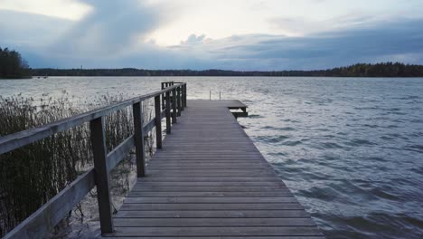 Empty-wooden-pier-at-a-lake-on-a-windy-autumn-evening