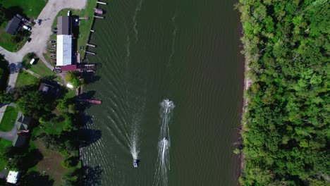 Top-View-over-Two-Jet-Skis-Passing-in-the-Fox-River-next-to-an-Small-Dock,-Crystal-Lake,-Illinois