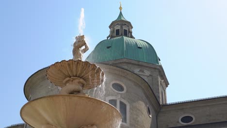 Cerca-De-Una-Fuente-Con-Agua-Corriente-Frente-A-La-Catedral-De-Salzburgo
