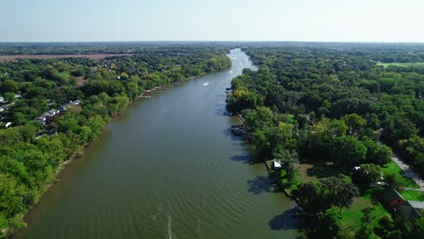 Eine-Luftdrohne-Fängt-Den-Fox-River-Ein,-Während-Einige-Boote-Navigieren,-Während-Er-Sich-Durch-Eine-üppige-Waldlandschaft-Im-Crystal-Lake,-Illinois,-USA,-Schlängelt