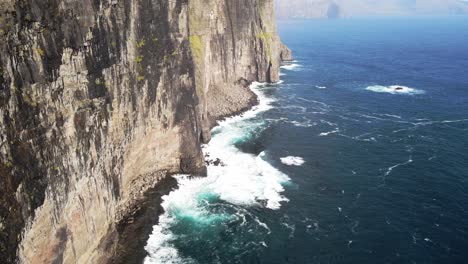 Distant-drone-footage-of-cliffs-and-the-Witch-Finger-at-Sandavagur-on-the-Vagar-island-in-the-Faroe-Islands