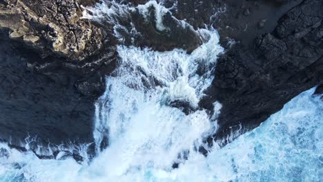 Close-rising-top-down-drone-footage-of-the-Bøsdalafossur-Waterfall-near-the-Leitisvatn-Lake,-aka-the-Floating-Lake,-on-the-Vagar-island-in-the-Faroe-Islands