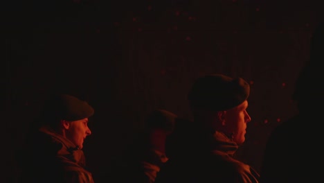 Armeesoldaten-Mit-Baskenmützen-Beobachten-Nachts-Ein-Riesiges-Feuer-Mit-Umherfliegenden-Partikeln