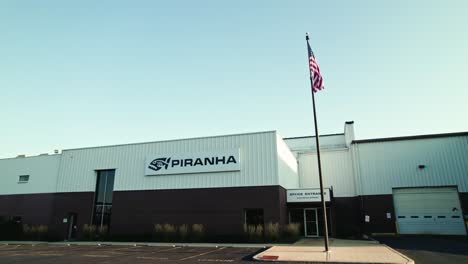 Travelling-Shot-of-Pirahana-Warehouse-with-Logo-and-USA-Flag,-Rockford-Illinois
