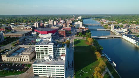Drone-aerial-shot-of-Rockford,-Illinois,-the-camera-follows-the-Rock-river,-offering-views-of-the-cityscape