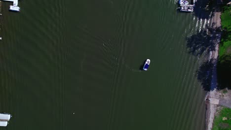 Top-view-aerial-drone-shot-following-the-river-with-boats-and-crossing-bridges,-yhat-connect-the-riverbanks-while-cars-drive-away